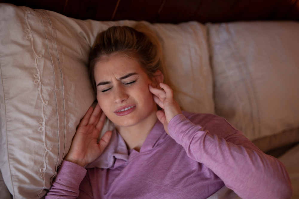 A woman in pain due to a toothache. Woman wakes up with soreness in her jaw after a night of sleep.